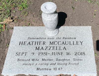 granite headstone with only lettering and a flower vase